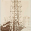 Scaffolding for the assemblage of the Statue of Liberty, of which the head is shown at left, in Paris