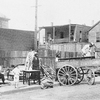 Negroes under protection of police leaving wrecked house in riot zone.