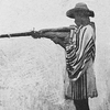 A Gora man firing gun from armpit