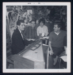 Caffe Cino. Robert Dahdah seated at harpsichord. Ken Burgess at far right in rear, washing dishes in the kitchen and Lee Marvin seated at far right in profile smoking cigarette