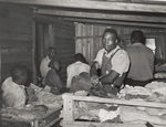 Negroes in bunkhouse in strawberry fields near Hammond, Louisiana; Note crude bunks, straw mattresses, and crowded conditions, April 1939.