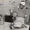 Household employee icing a cake