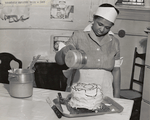 Household employee icing a cake