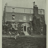 Charles Dickens reading in front of a house.