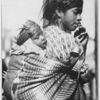 The crowds that assemble at the Guatemalan railway stations to meet the trains include many an Indian woman with the youngest of her numerous brood tied to her back by a homespun shawl of gaudy colours.
