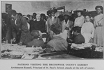 Patrons visiting the Brunswick County Exhibit; Archdeacon Russell, Principal of St. Paul's School, stands at the left of center.
