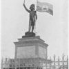 The Statue to Dessalines on the Champ de Mars, Port-au-Prince; He is represented as the declarer of Haitian independence in 1804; [This statue, which is of hollow metal with a flag of painted tin, is an ugly object, and ought to be removed.]