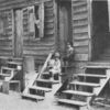 African American children sitting on the stairs in front of their house