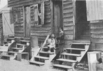African American children sitting on the stairs in front of their house