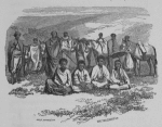 Group of people some in background with horses and four sitting on the ground