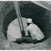 The cement well cap is lowered down the cleared well with a two purchase block and tackle. John Hardesty Well Project, Charles County, Maryland, July, 1941.