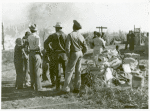 Negro agricultural laborers watching one of their houses burn to the ground; All they have left is piled on the ground.
