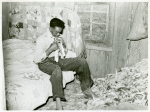 Southeast Missouri Farms. Son of a sharecropper dressing in a combination of bedroom and corn crib, 1938.