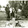 Negro couple at grave of relative; All Saint's Day in cemetery at New Roads, La.