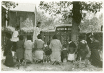 [African American women and children commemorating their lost relatives on their knees in a cemetery on All Saints' Day, 1938.]