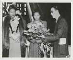 Beulah Whittington, an African American shipyard worker, receiving a bouquet of American Beauty roses from Frank Stearns of Richmond Shipyard No. 2 as Katie Lewis, the African American matron of honor, looks on during the ship launching of the SS S. Hall Young at Richmond Shipyard No. 2