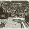 Lena Horne, African American actress, singer, and sponsor of the SS George Washington Carver, standing on stage and addressing a crowd at a war bond rally before the launching of the Liberty ship SS George Washington Carver
