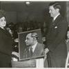 Mrs. Ira T. Lewis, wife of the president of the Pittsburgh Courier Publishing Company, presents a photograph of the late Robert L. Vann, former publisher of the Pittsburgh Courier, to a representative of the shipyard workers at the launching of the Liberty ship SS Robert L. Vann