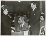 Mrs. Ira T. Lewis, wife of the president of the Pittsburgh Courier Publishing Company, presents a photograph of the late Robert L. Vann, former publisher of the Pittsburgh Courier, to a representative of the shipyard workers at the launching of the Liberty ship SS Robert L. Vann