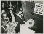 Mrs. John H. Sengstacke, sponsor of the Liberty ship SS Robert S. Abbott, christens the ship by breaking a bottle of champagne against its hull on the day of its launching, Permanente Metals Corporation Shipyard No. 2
