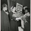 Miss Lulu Mae Hamel (flower girl and shipyard worker) presenting a bouquet of roses to Mrs. John H. Sengstacke (sponsor) during the launching of the Liberty ship SS Robert S. Abbott at Permanente Metals Corporation Shipyard No. 2