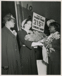 Miss Lulu Mae Hamel (flower girl and shipyard worker) presenting a bouquet of roses to Mrs. John H. Sengstacke (sponsor) during the launching of the Liberty ship SS Robert S. Abbott at Permanente Metals Corporation Shipyard No. 2