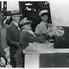 Mrs. Edith Savoy Morgan, daughter of the late Edward A. Savoy, christens the Liberty ship SS Edward A. Savoy by breaking a bottle of champagne against its hull while others look on, Bethlehem-Fairfield Shipyard