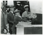 Mrs. Edith Savoy Morgan, daughter of the late Edward A. Savoy, christens the Liberty ship SS Edward A. Savoy by breaking a bottle of champagne against its hull while others look on, Bethlehem-Fairfield Shipyard