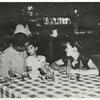 First Lieutenant and Mrs. Edward Mitchell, of Cincinnati, Ohio, and daughter Janice Althea, are shown at dinner given at Leghorn, Italy, for dependents who arrived on June 3 aboard the SS Thomas Barry