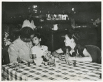 First Lieutenant and Mrs. Edward Mitchell, of Cincinnati, Ohio, and daughter Janice Althea, are shown at dinner given at Leghorn, Italy, for dependents who arrived on June 3 aboard the SS Thomas Barry