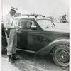 At a road block located near Viareggio, Private First Class George Weatheroy, Portland, Oregon, inspects tire certificate of an Italian driver