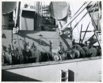 Corporal Calvin James of Alabama, and Technician Fifth Grade Joseph Wooten of North Carolina, operating a winch aboard a Liberty ship in the harbor at Marseille