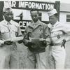 African American officer candidate Perry Johnson (left) and Corporal George Bethel (center) standing and reading papers while African American officer candidate Travis L. Banks (right) looks on, Fort Benning, Georgia