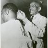 African American veteran Joseph N. Stevens, 72, cutting the hair of an African American serviceman, Fort Benning, Georgia