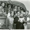African American soldiers of the 372nd sitting in a truck with their guns and looking at papers