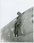 African American Sergeant James C. Snowden of the 555th Parachute Infantry Battalion standing in the doorframe of a C-47 transport plane, preparing to jump