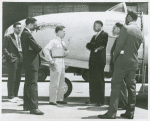 A white P-80 pilot standing next to a plane and speaking to African American Marcus H. Ray, Civilian Aide to the Secretary of War, as four other African American men look on and listen, Army Air Forces Wright Field, Dayton, Ohio