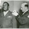 Colonel R. L. Salzmann pins a first Lieutenant's bar on the shoulder of African American Lieutenant Jesse J. Holbert