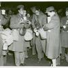 Red Cross worker pouring coffee into the cup of an African American member of the Women's Army Corps as other African American WACs stand with their coffee and doughnuts and look on, Staten Island Terminal, New York Port