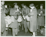 Red Cross worker pouring coffee into the cup of an African American member of the Women's Army Corps as other African American WACs stand with their coffee and doughnuts and look on, Staten Island Terminal, New York Port