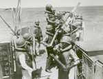 African American seamen delivering shells and loading the anti-aircraft gun aboard a vessel on the Atlantic patrol