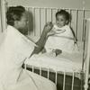 African American nurses' aide feeding an African American infant