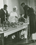 African American veterans, disabled ex-service men patients in U.S. Veterans Hospital, Tuskegee, Alabama, making Buddy Poppies (red artificial flowers) for the Veterans of Foreign Wars Sale which will be conducted nationally during the week preceding Memorial Day