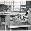 Three African American women constructing a wooden skeleton frame