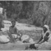 Haitian women washing clothes in a river.]