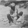 Haitian woman washing clothes in a river.]