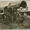 Woman and children in a covered wagon.