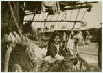 Girl in a covered wagon, smiling.