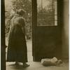 Woman looking down at a baby asleep on the floor.