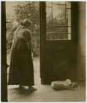 Woman looking down at a baby asleep on the floor.